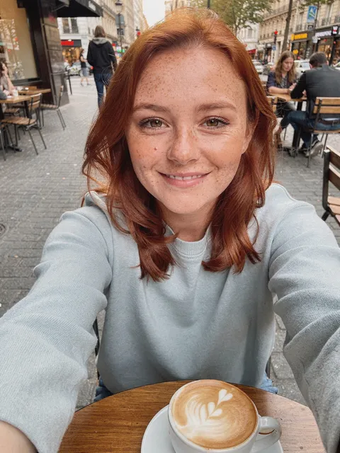 A selfie at a café table, with a latte.